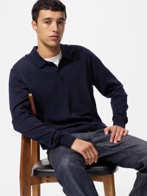 A seated male model wearing a merino knit polo sweater.