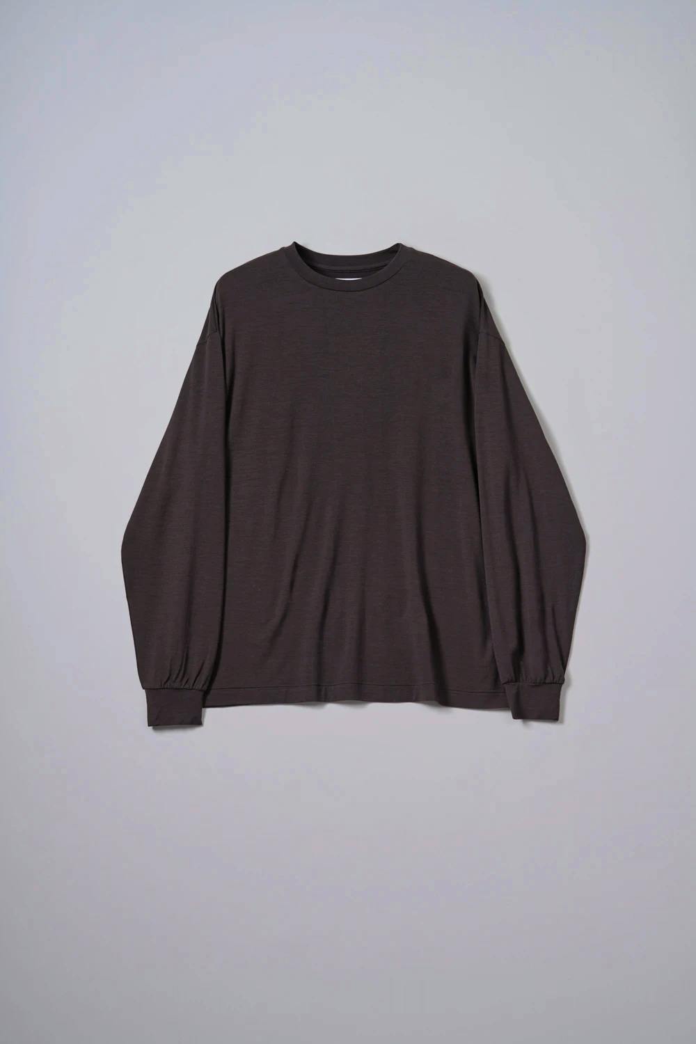 Flat-lay dark long-sleeve women's merino wool tee displayed on a light background.