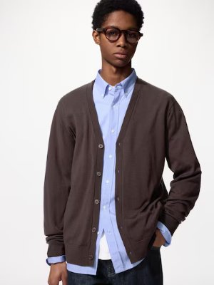 Model wearing a brown V-neck merino cardigan over a light blue button-down shirt.