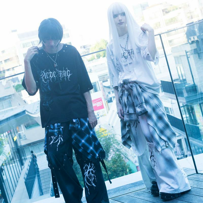 Two models stand on a balcony wearing the Messenger 2way T-shirt in black and white with printed graphics.
