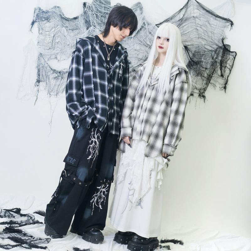 A female model wears the Messenger Shirt, an oversized plaid women's shirt, standing beside a male model against a white backdrop.