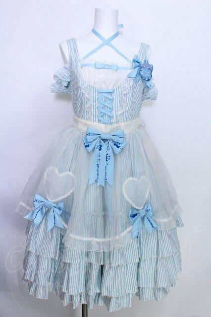 Light blue Metamorphose Cinnamoroll-collaboration jumper skirt with attached apron, bows, and heart appliqués displayed on a mannequin.