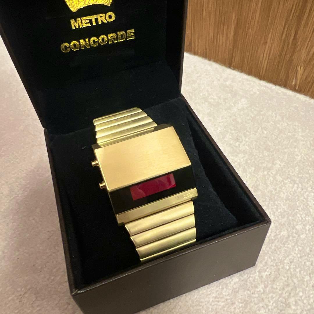 Gold-tone Metro Concorde 70’s digital watch with a red display shown inside its black presentation box.