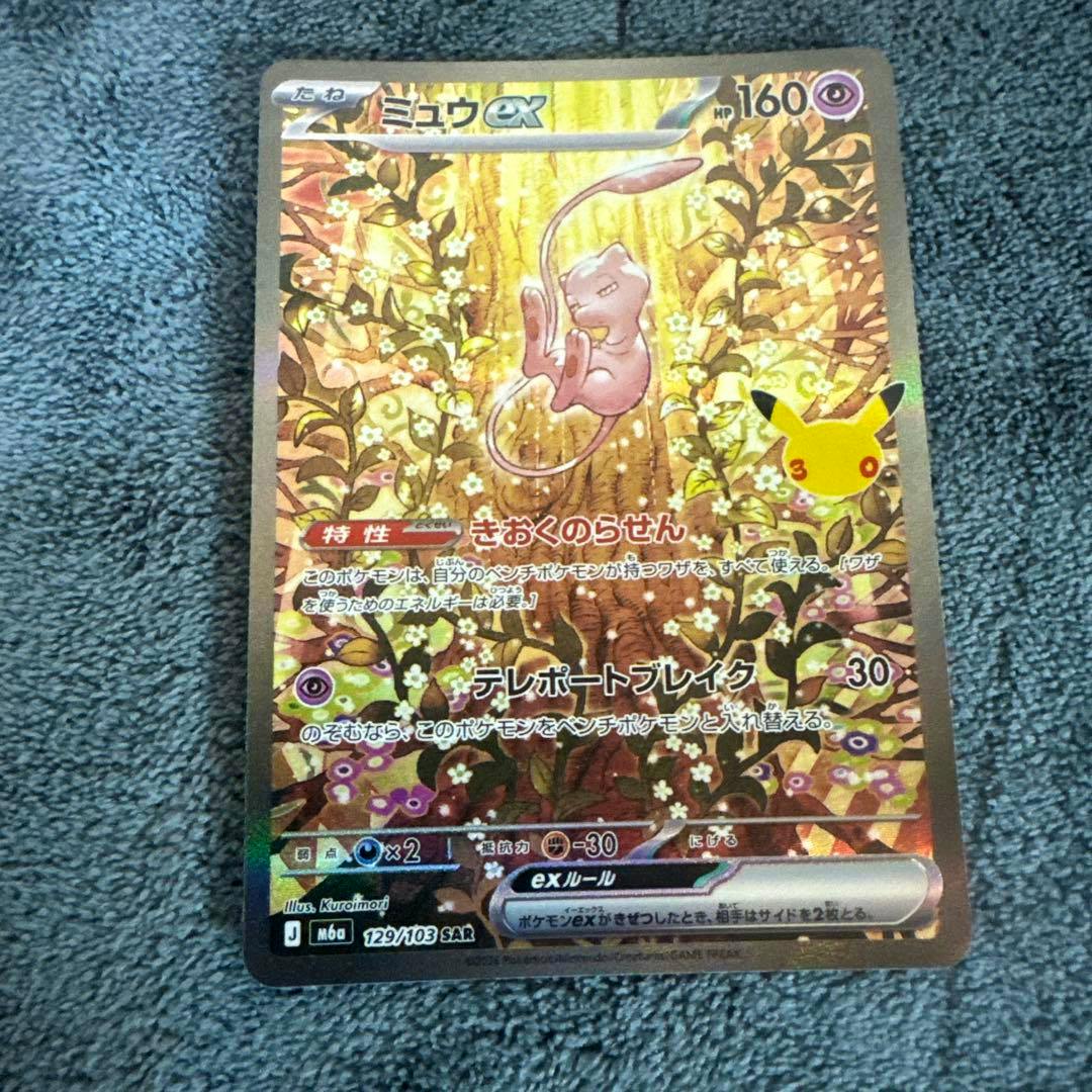Front of the Japanese ミュウex SAR MEGA trading card showing the holo illustration of Mew on a textured background.