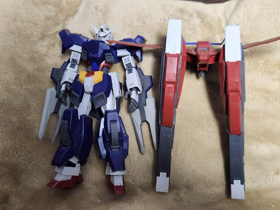 MG Gundam AGE-1 Full Gransa model parts laid flat on a beige surface, showing the main body, limbs, and large red backpack units.