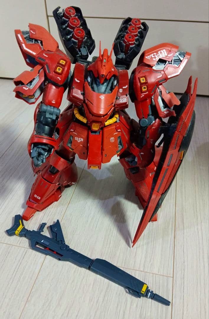 Assembled MG Sazabi Ver.Ka model kit posed on the floor with its rifle and shield visible.