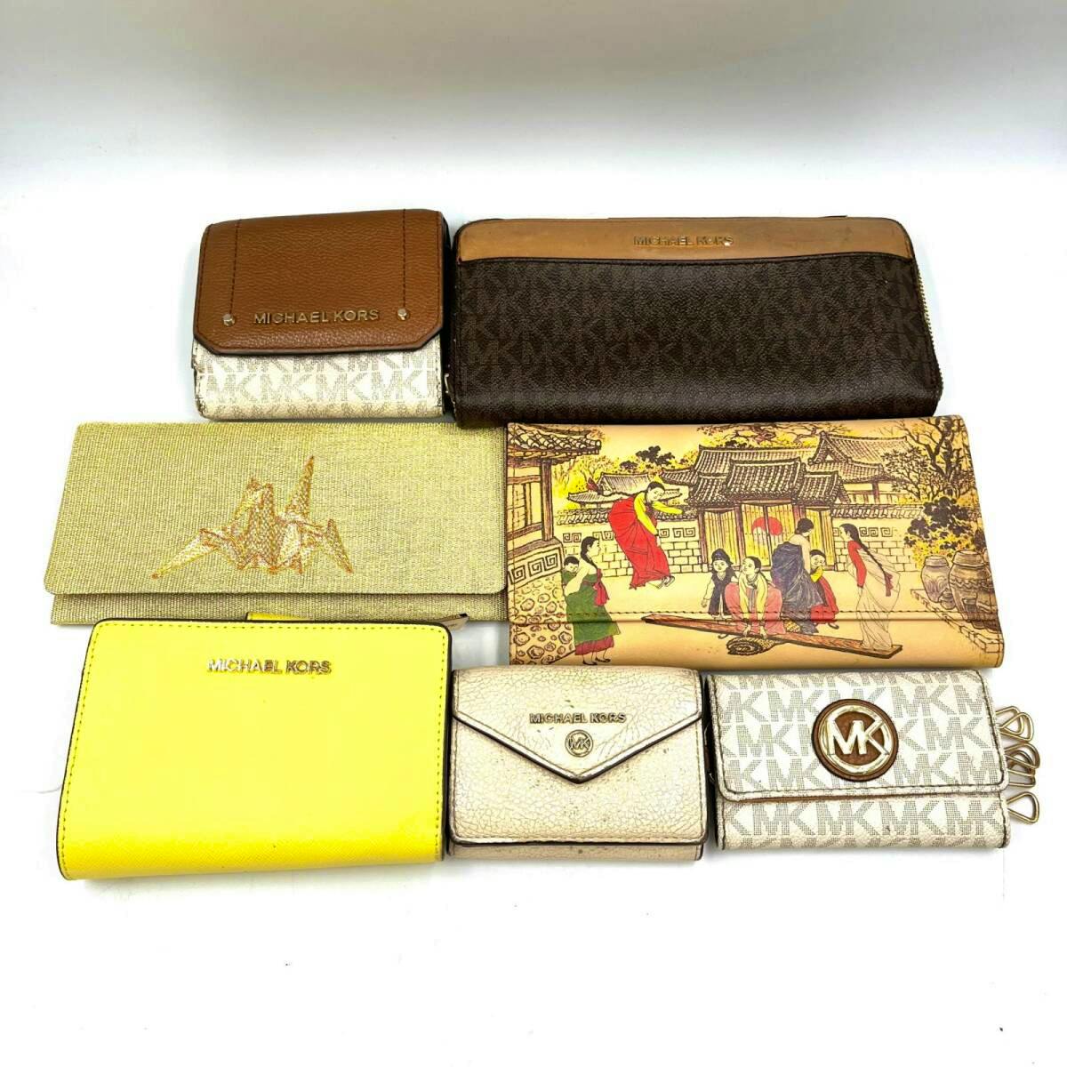 Seven wallets, including Michael Kors branded long and folding wallets, arranged on a white background.
