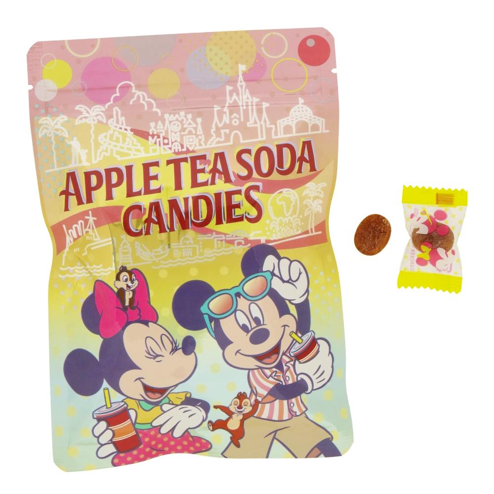 A colorful bag labeled "APPLE TEA SODA CANDIES" featuring Mickey and Minnie, with two loose candies and one wrapped candy beside it.