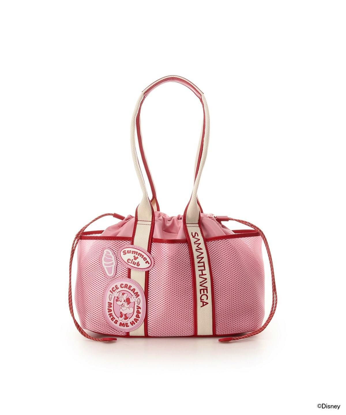 Front view of a pink nylon Minnie Mouse logo-tape tote bag with cream straps and decorative patches.