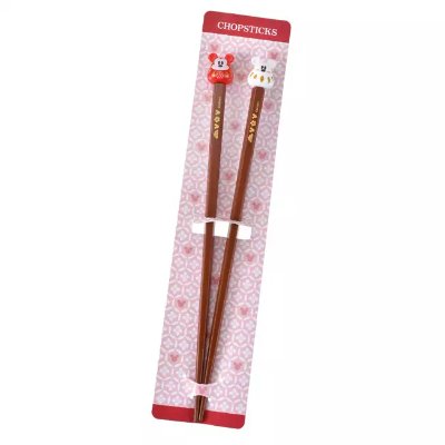 Two wooden Mickey New Year Daruma 2026 chopsticks displayed on a pink patterned backing card.