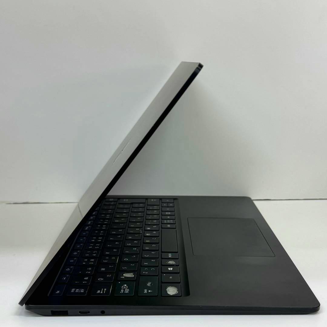 Side view of a Microsoft Surface Laptop 4 partially open showing the keyboard, trackpad, and left-side ports on a white background.
