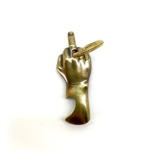 Antique gold-colored metal keycover shaped like a hand showing the middle finger with a key ring attached.