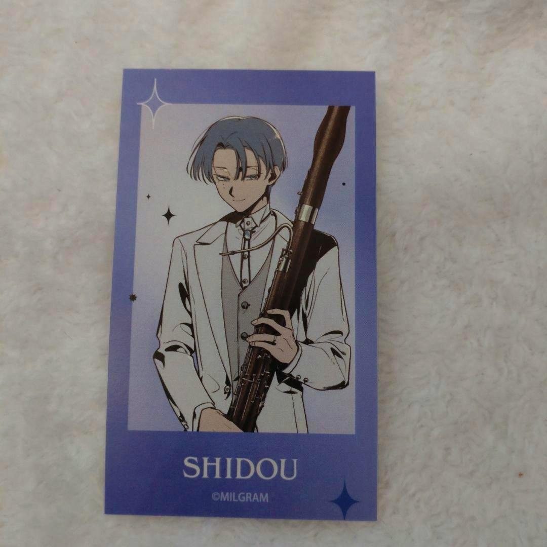 Photocard showing the Milgram character Shidou in a white suit holding a woodwind instrument with a purple border and the text "SHIDOU".