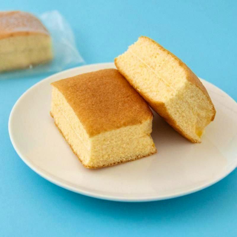 Two pieces of milk-sandwich cake on a white plate against a blue background.