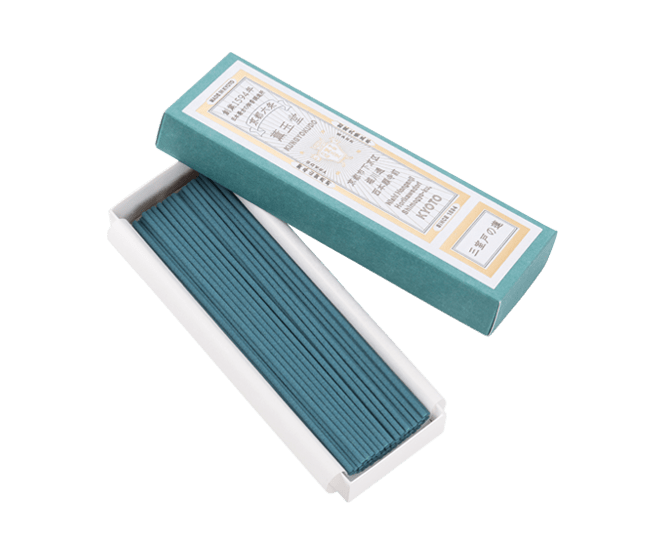 An open paper box of incense sticks with the lid beside it on a black background.