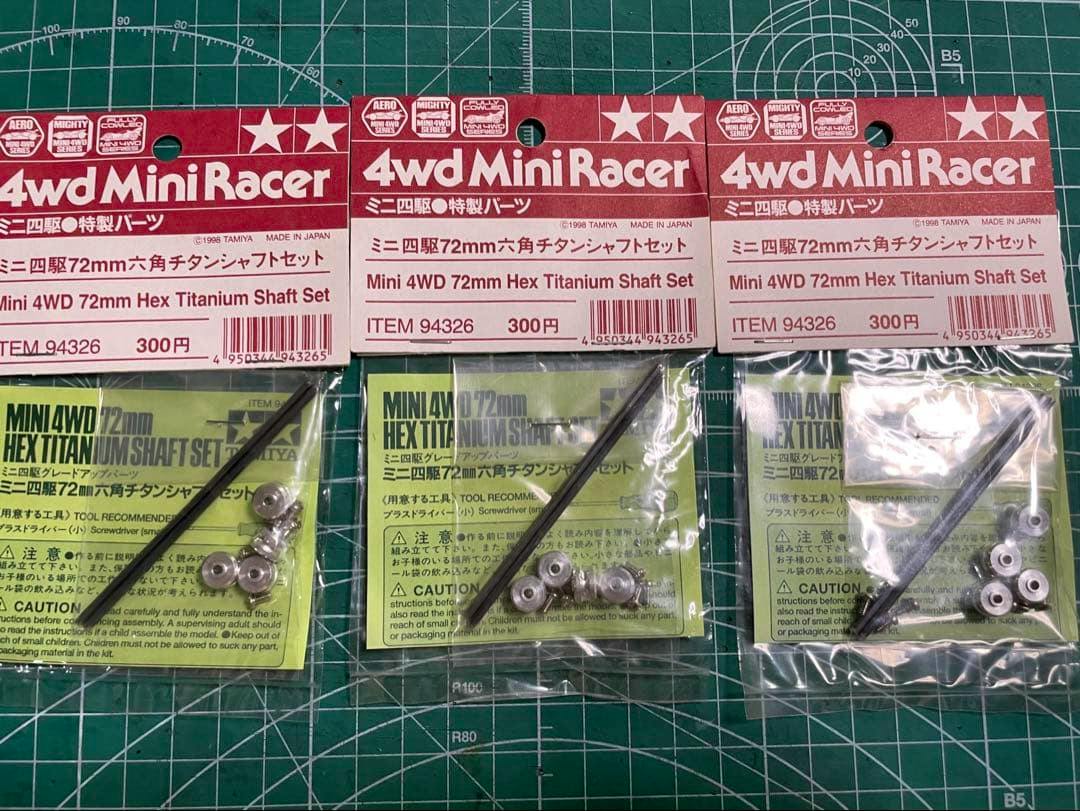 Three packaged Mini 4WD 72mm hex titanium shaft sets shown side-by-side in their retail packaging on a green cutting mat.