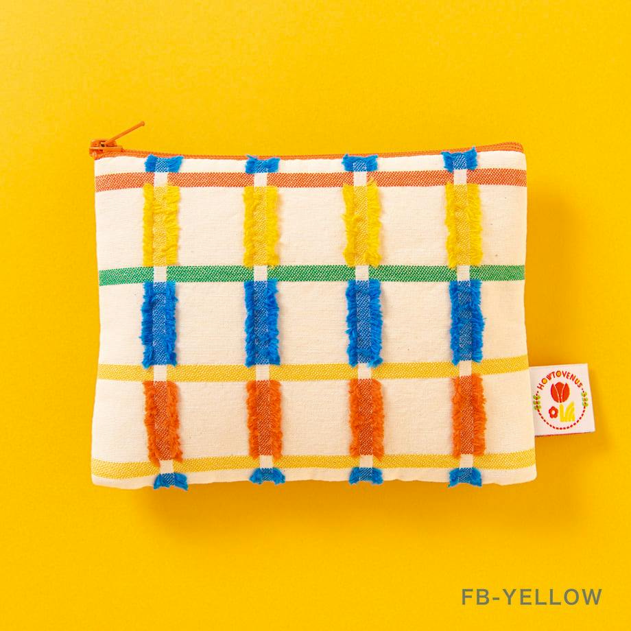 A cotton mini pouch with a cream base and multicolored checkered pattern with textured vertical stripes, photographed on a yellow background.