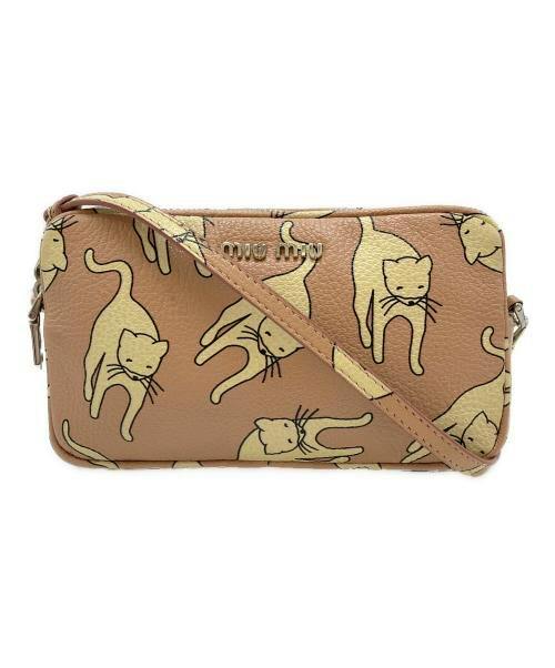 Front view of a brown synthetic leather mini shoulder bag with an all-over cat print and strap.