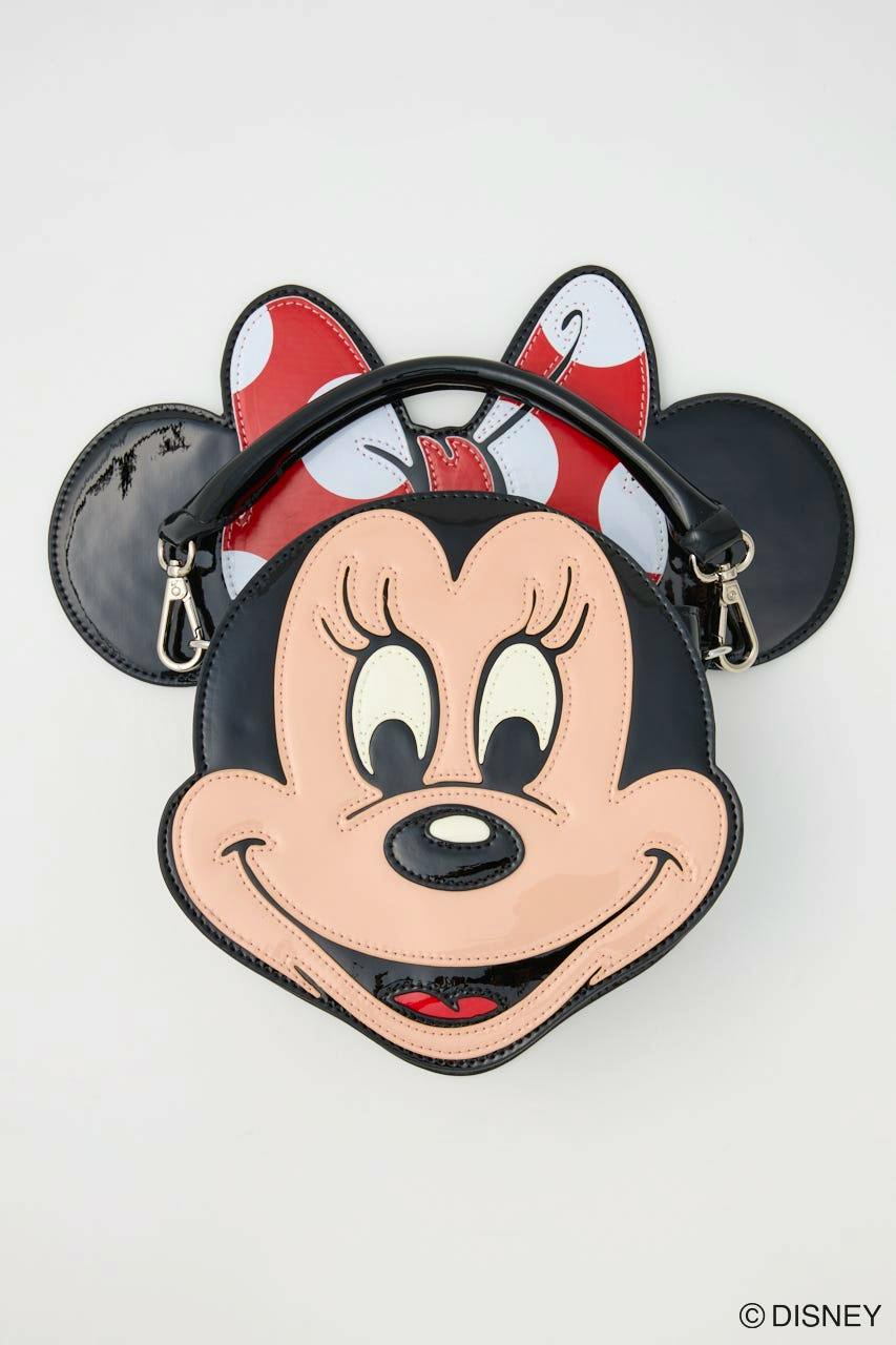 Front view of a Minnie Mouse face-shaped synthetic leather bag showing the face, red polka-dot bow, and a top handle.