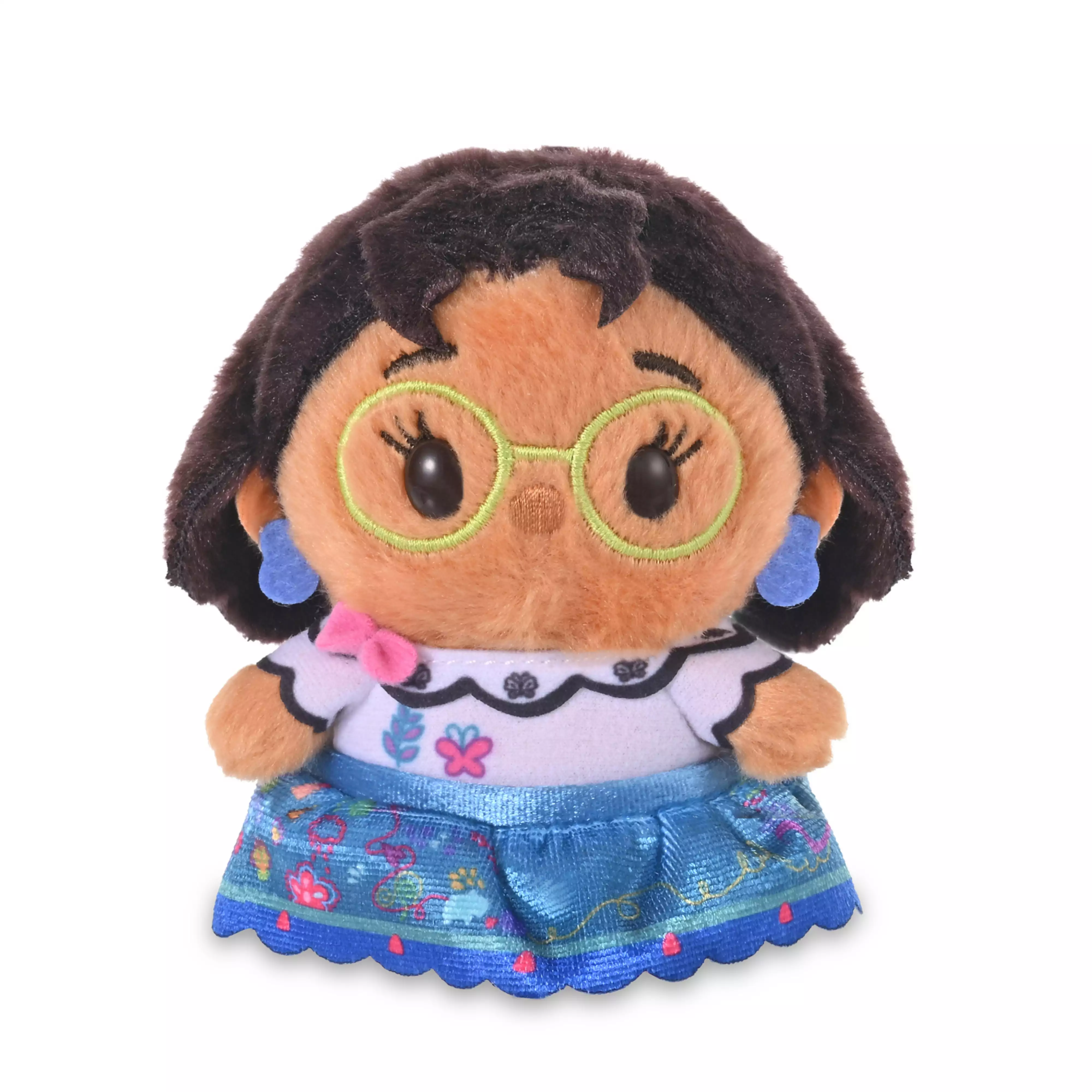 Front view of the Mirabel plush toy wearing round green glasses, blue earrings, a patterned white top, and a blue skirt.