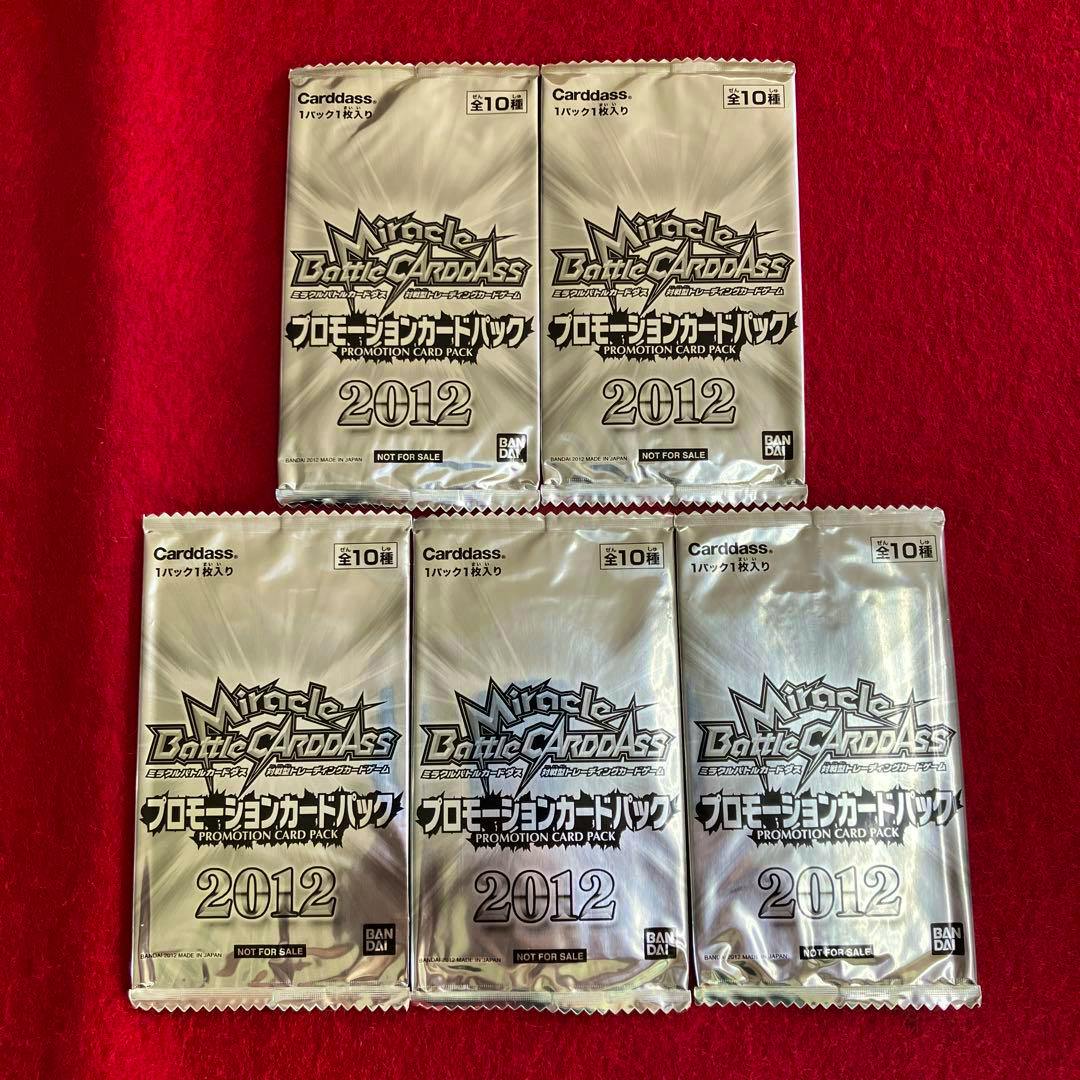 Five sealed Miracle Battle Carddass 2012 promotion card packs laid out on a red background.