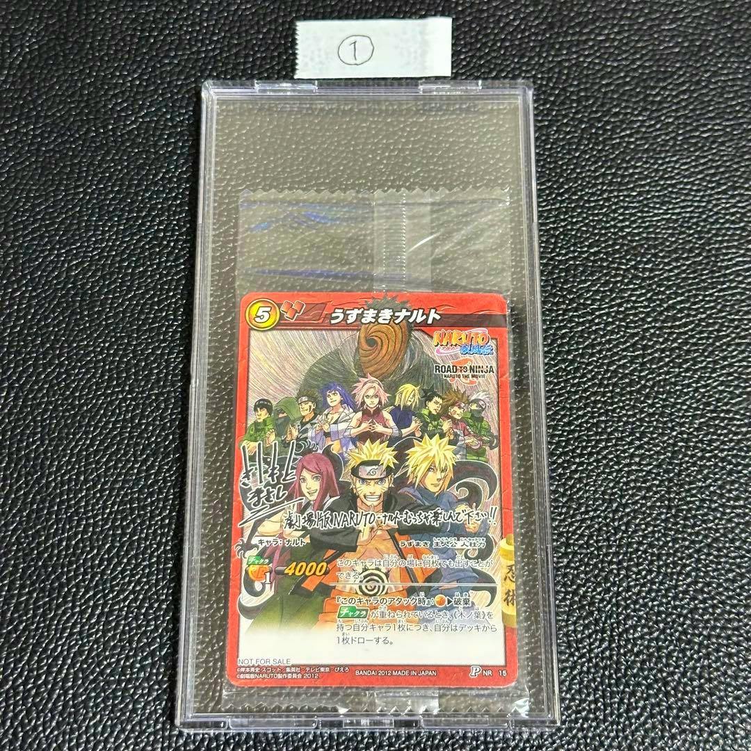 Photograph of the Naruto trading card (うずまきナルト) inside a clear plastic sleeve on a black textured surface.