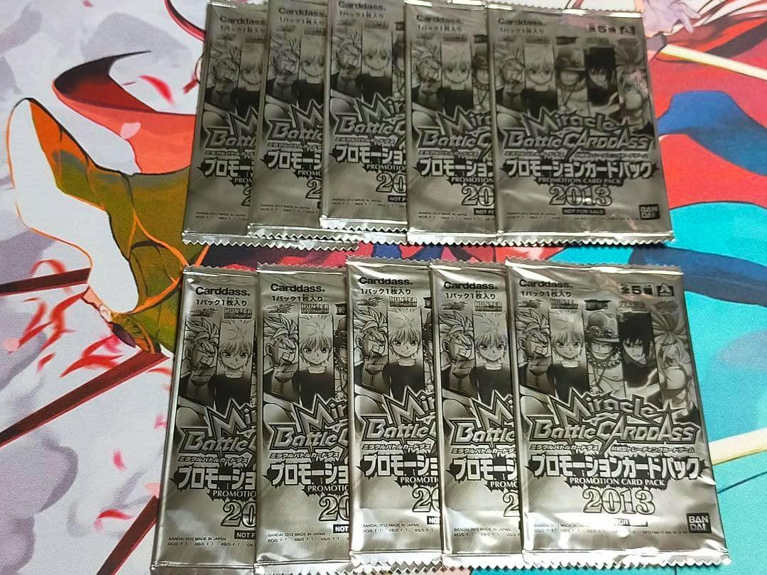 Ten Miracle Battle Carddass 2013 promotion card packs arranged on a colorful playmat.