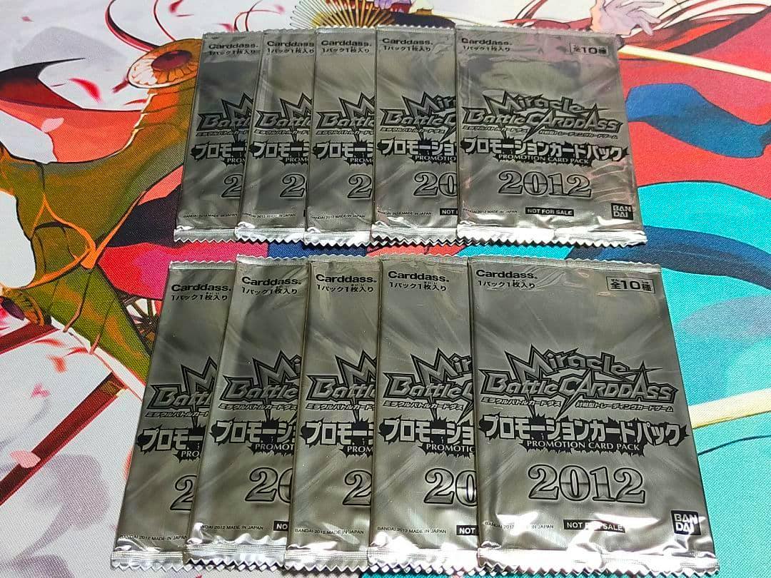 Ten sealed Miracle Battle Carddass 2012 promotional card packs arranged on a colorful playmat.