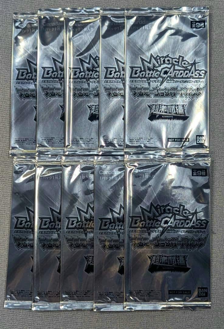 Ten sealed Miracle Battle Carddass promotional card packs arranged in two rows on a fabric surface.