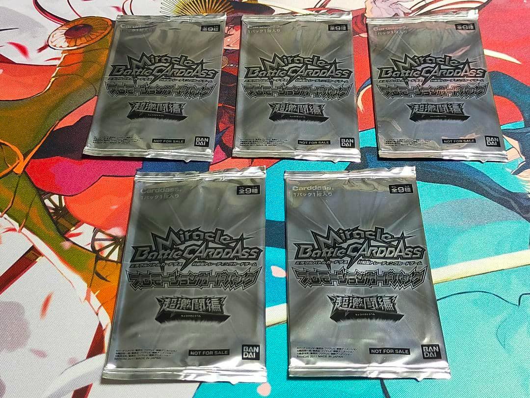Five sealed Miracle Battle Carddass promotional card packs arranged on a playmat.