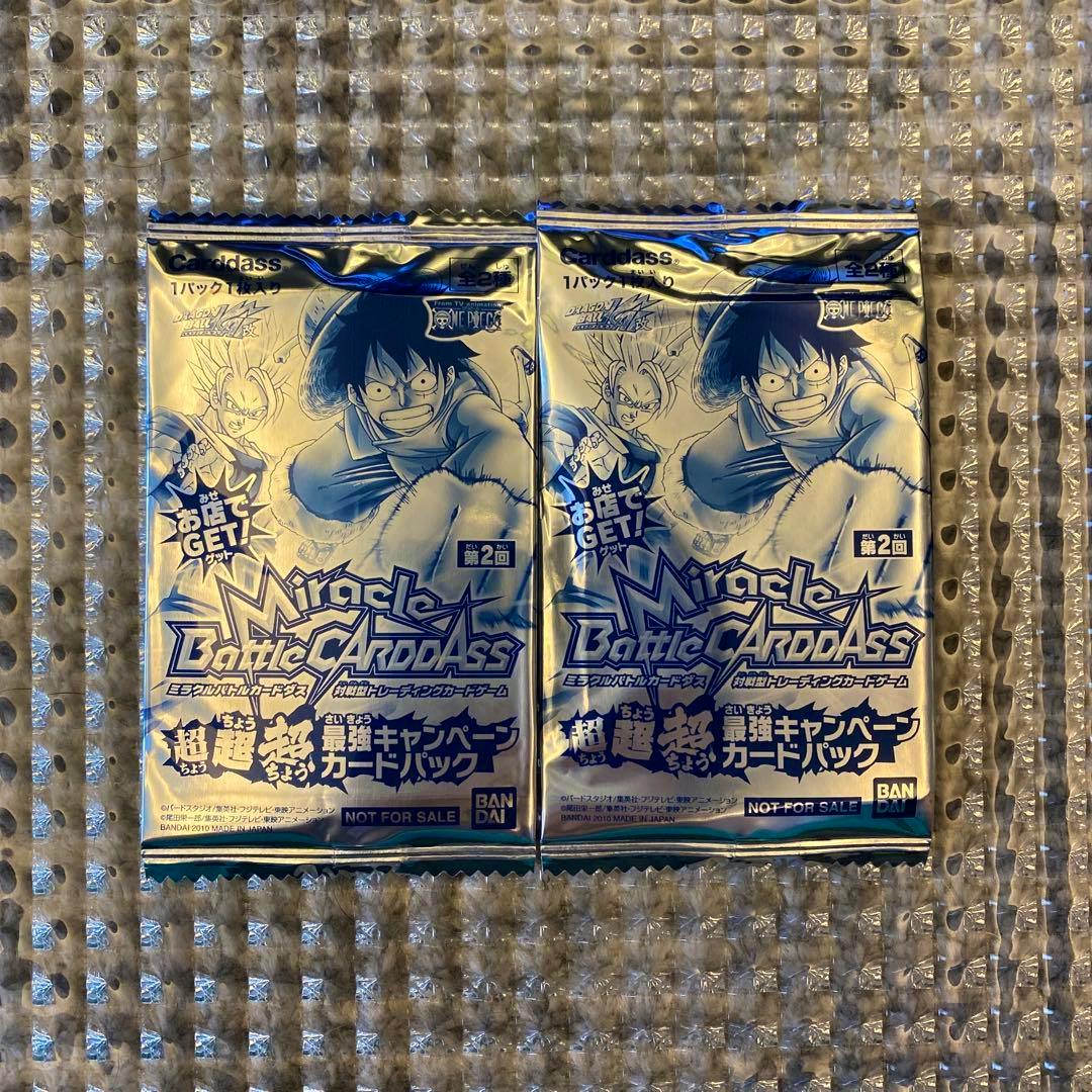 Two unopened Miracle Battle Carddass foil card packs featuring One Piece artwork shown on bubble wrap.