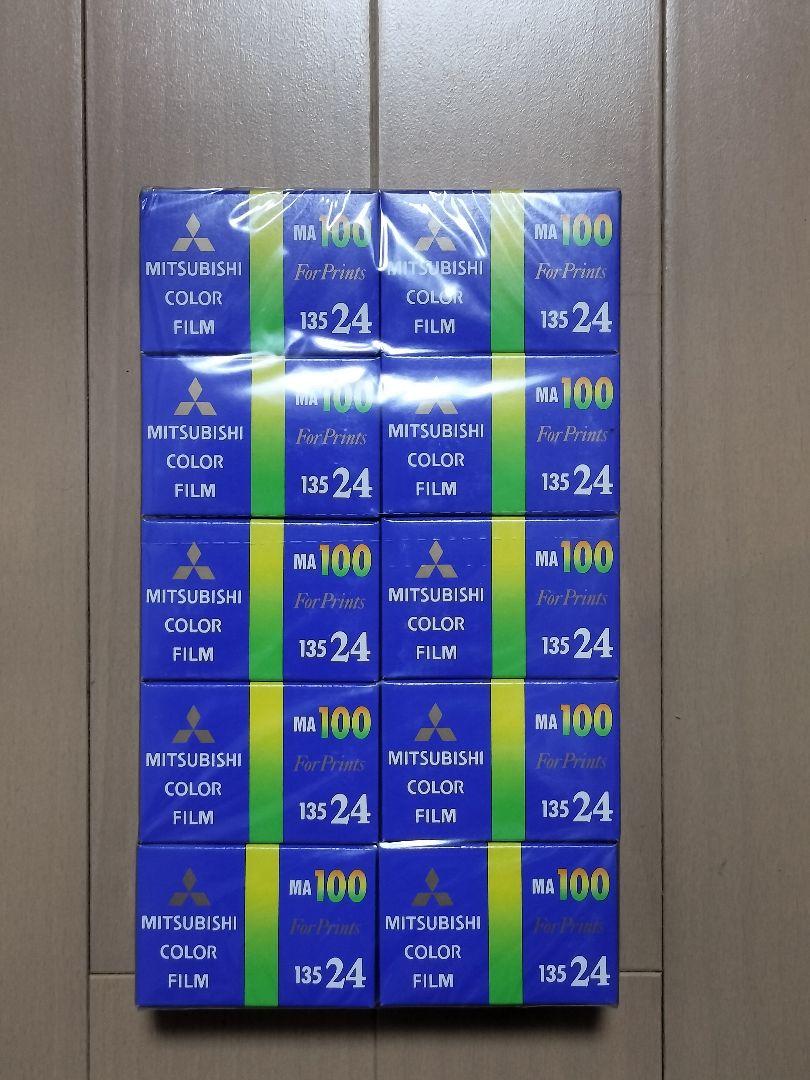 Multiple boxed MITSUBISHI MA100 35mm color film packages labeled 135 24 arranged on a wooden floor.