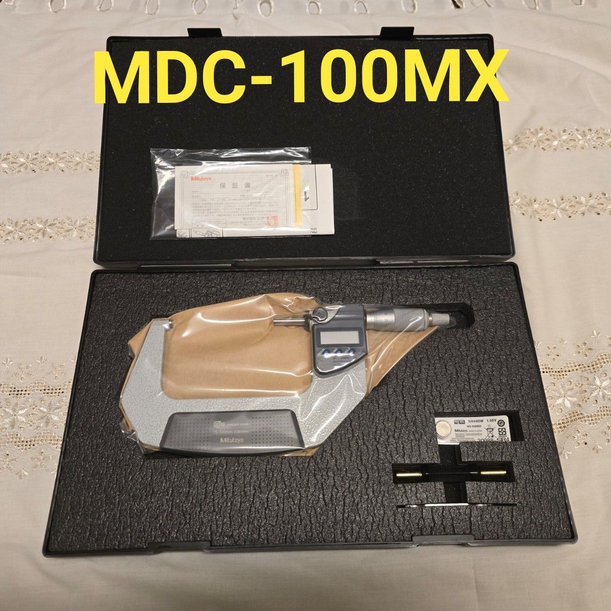 Mitutoyo MDC-100MX digital micrometer in its foam-lined protective case with accessories and documentation.