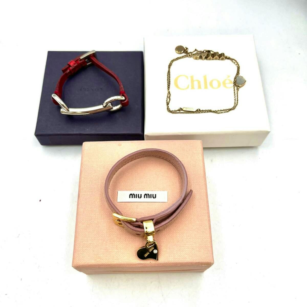 Three bracelets from Miu Miu, Chloe, and Prada are displayed on their boxes, including a pink wrap bracelet, a gold chain bracelet, and a red strap bracelet.