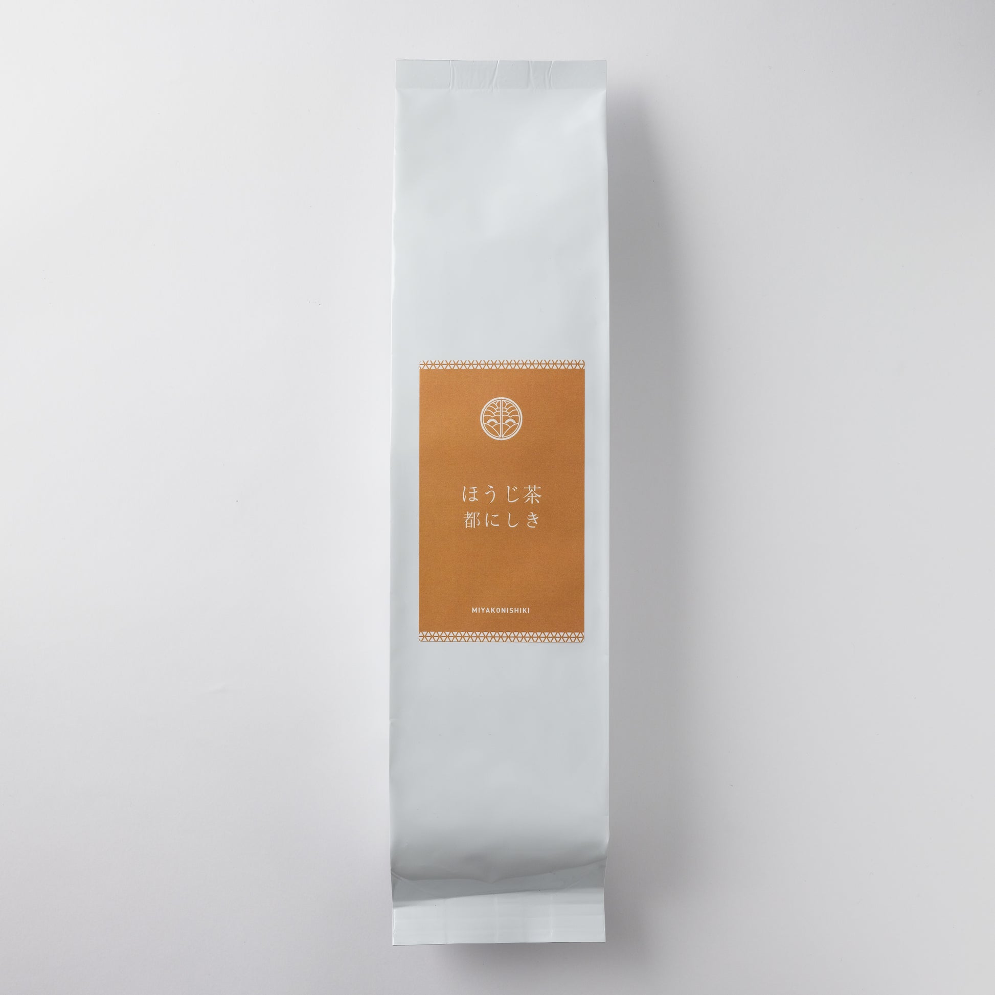 White sealed pouch of loose-leaf tea with a brown rectangular label reading ほうじ茶 都にしき.