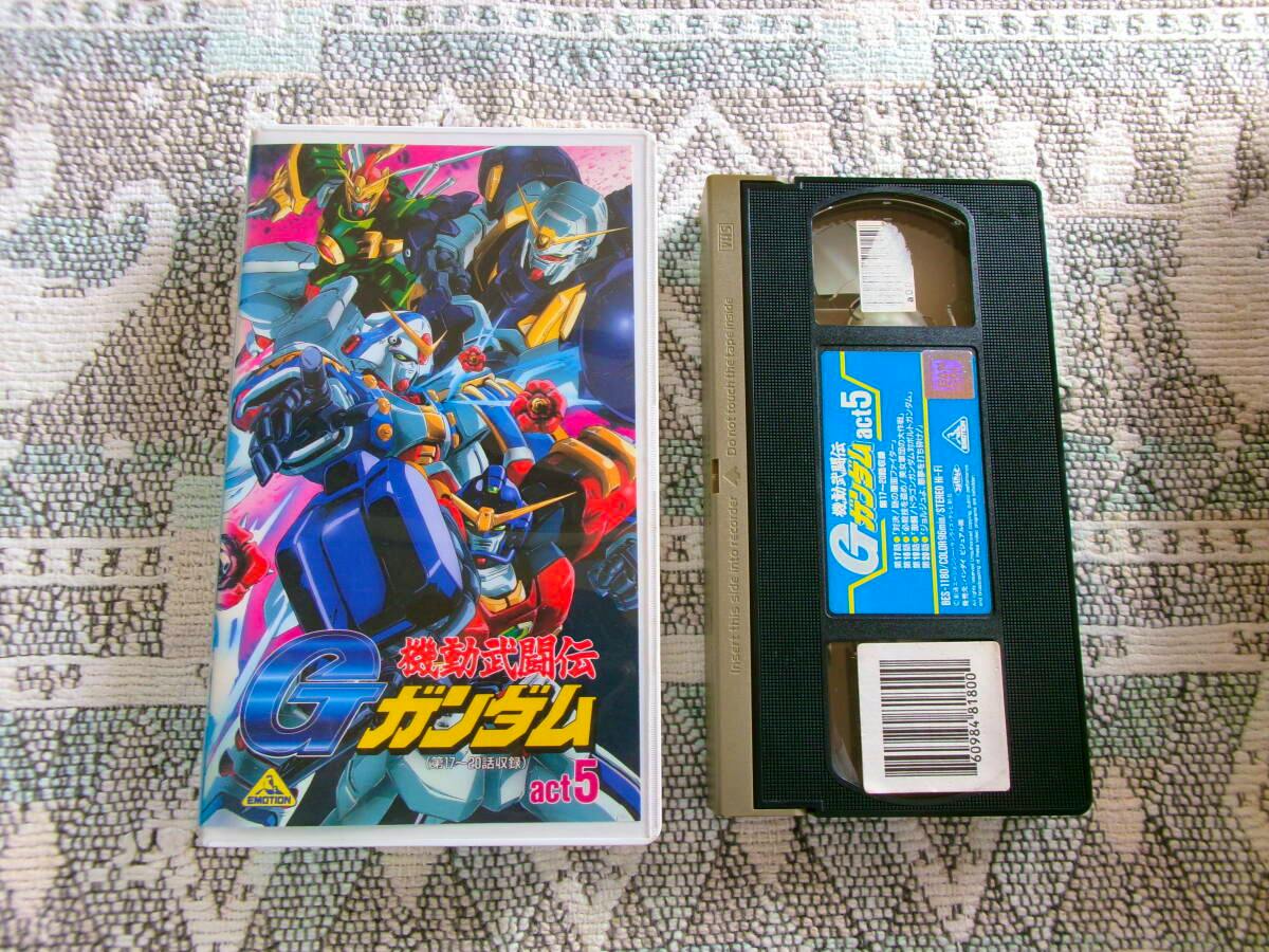 VHS tape next to its illustrated front cover case for G Gundam act.5 on a patterned cloth surface.