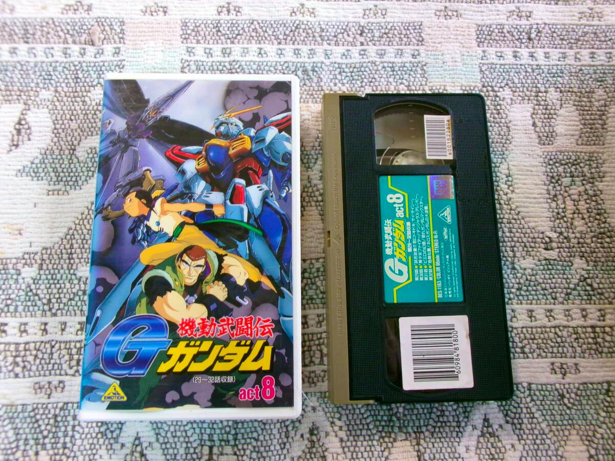 VHS tape and its illustrated case for 機動武闘伝 Ｇガンダム act.8 shown side by side on a patterned surface.
