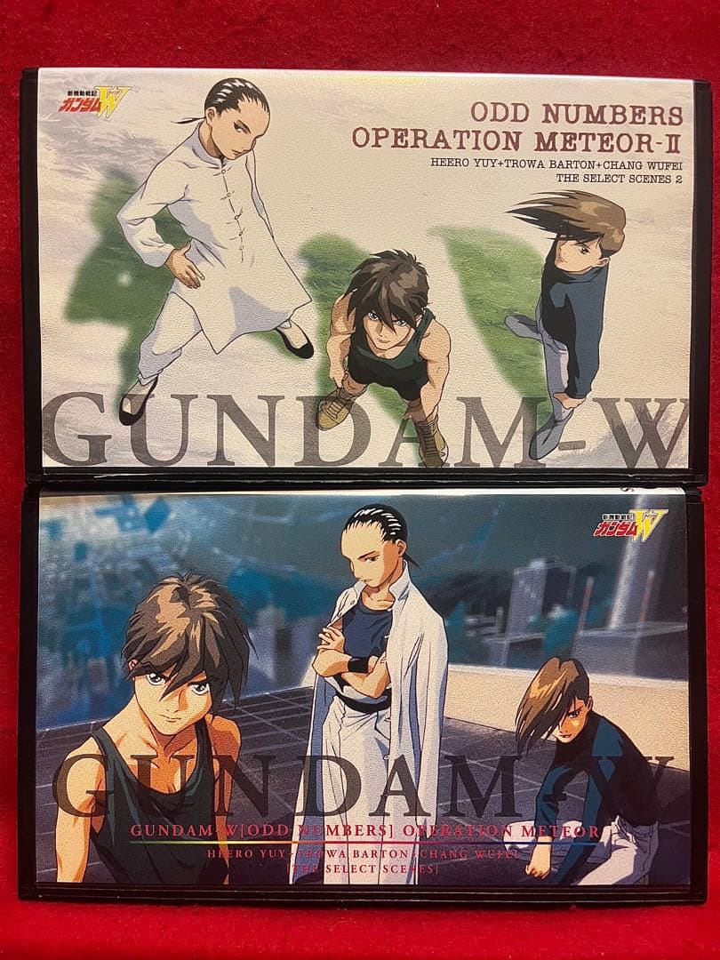 Photograph of a Gundam W VHS tape cover showing characters Heero, Trowa, and Wufei in artwork.