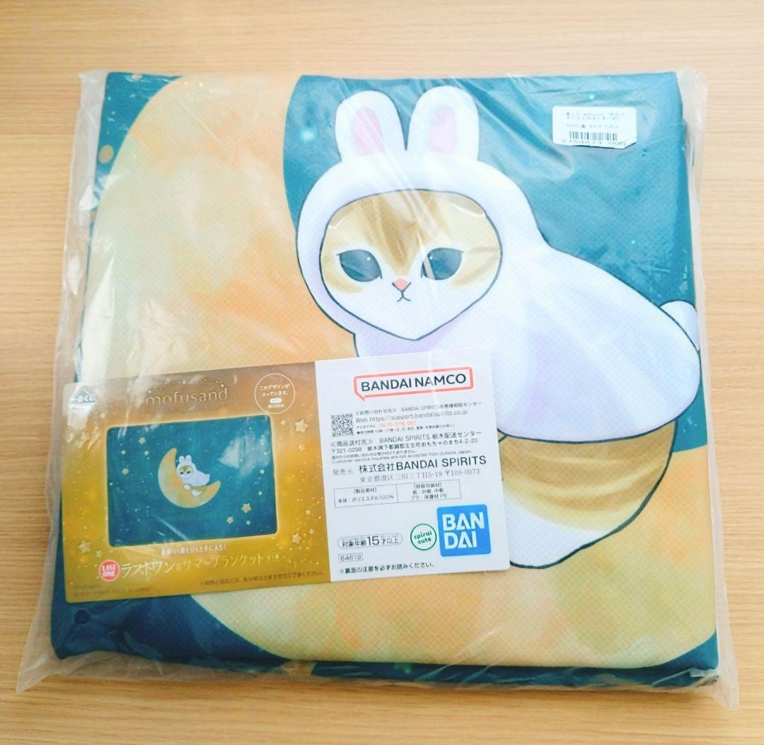 Folded packaged polyester blanket showing a cat-in-bunny-hood design and a Bandai Namco label.