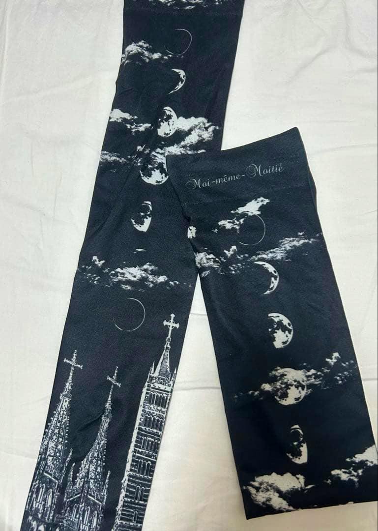 Flat-lay photo of black Moi-même-Moitié socks with white moon, cloud, and cathedral tower prints and brand text.