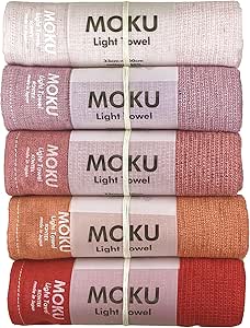 Five folded Moku face towels in a stacked set showing gradient sunset colors, each with a MOKU label.
