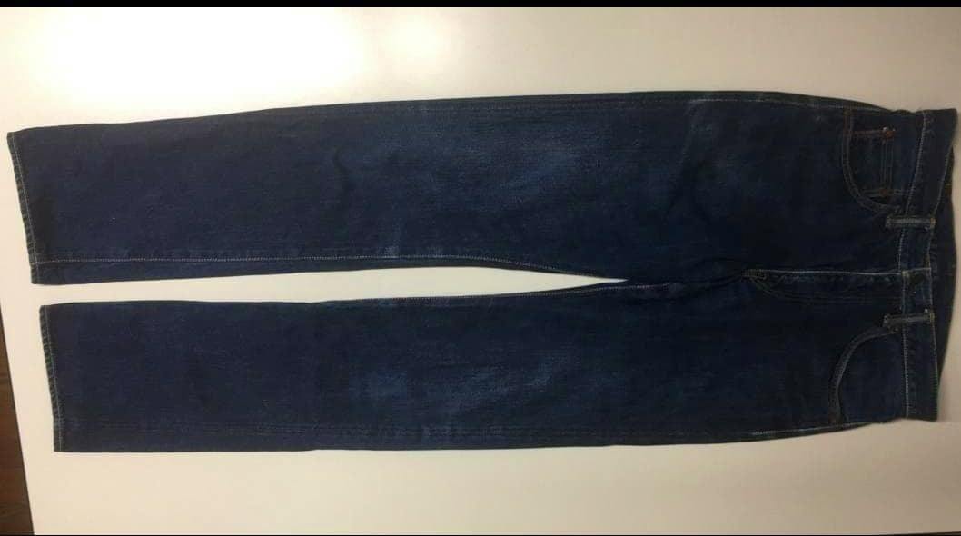 Dark blue Momotaro jeans laid flat on a light background showing the full pant length and tapered, slim-tapered legs.