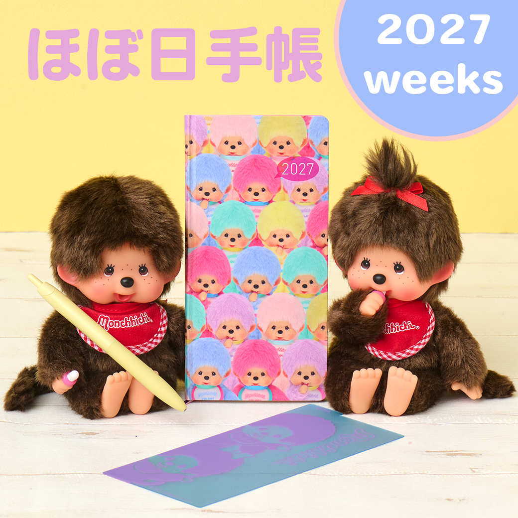 A 2027 weeks Hobonichi Techo diary with a colorful Monchhichi cover displayed between two Monchhichi dolls with a card on the table.