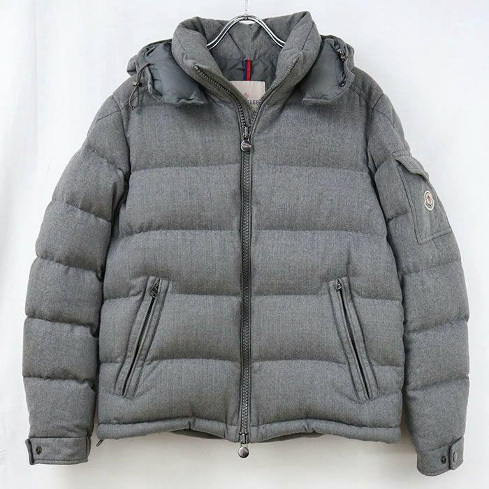 Front view of a grey Moncler men's down jacket (MONTGENEVRE) hanging on a hanger.