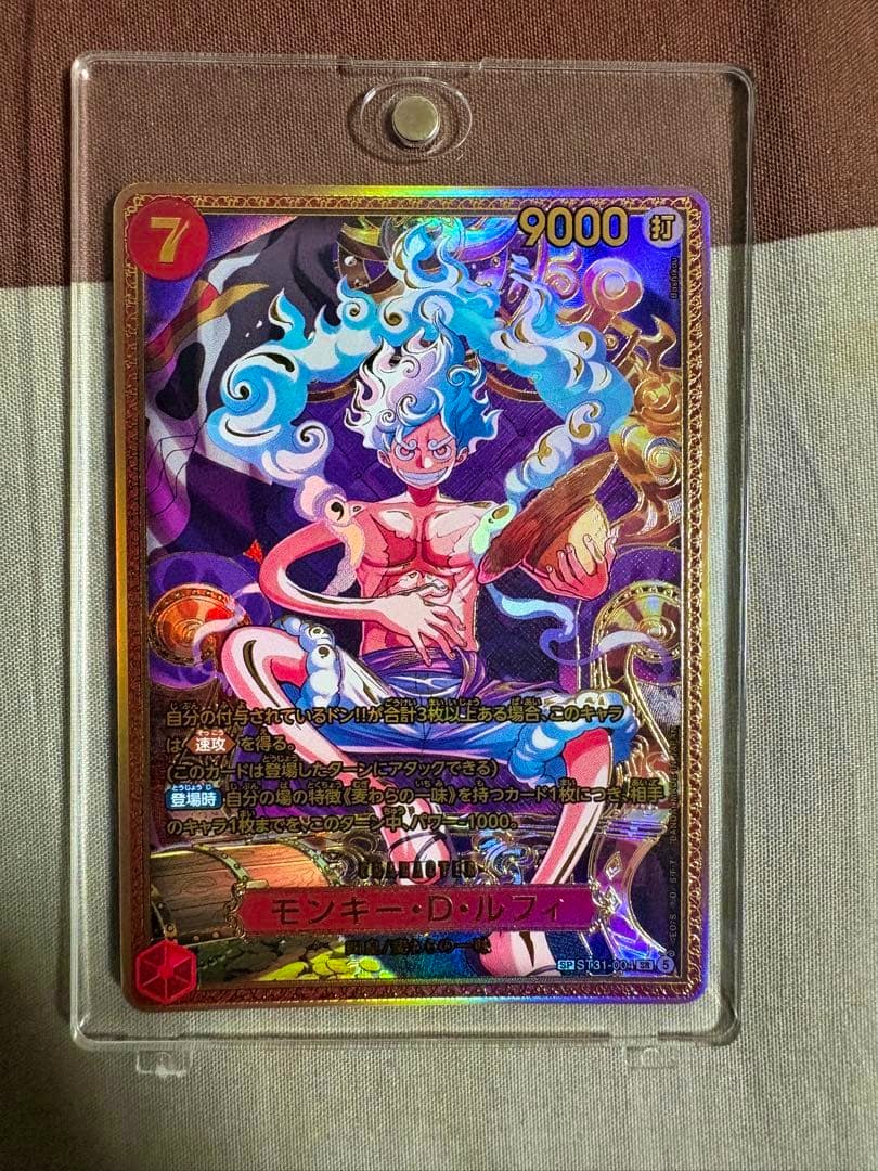 Photo of the trading card モンキー・D・ルフィ SP ST31-004 in a clear plastic sleeve showing the full front artwork.
