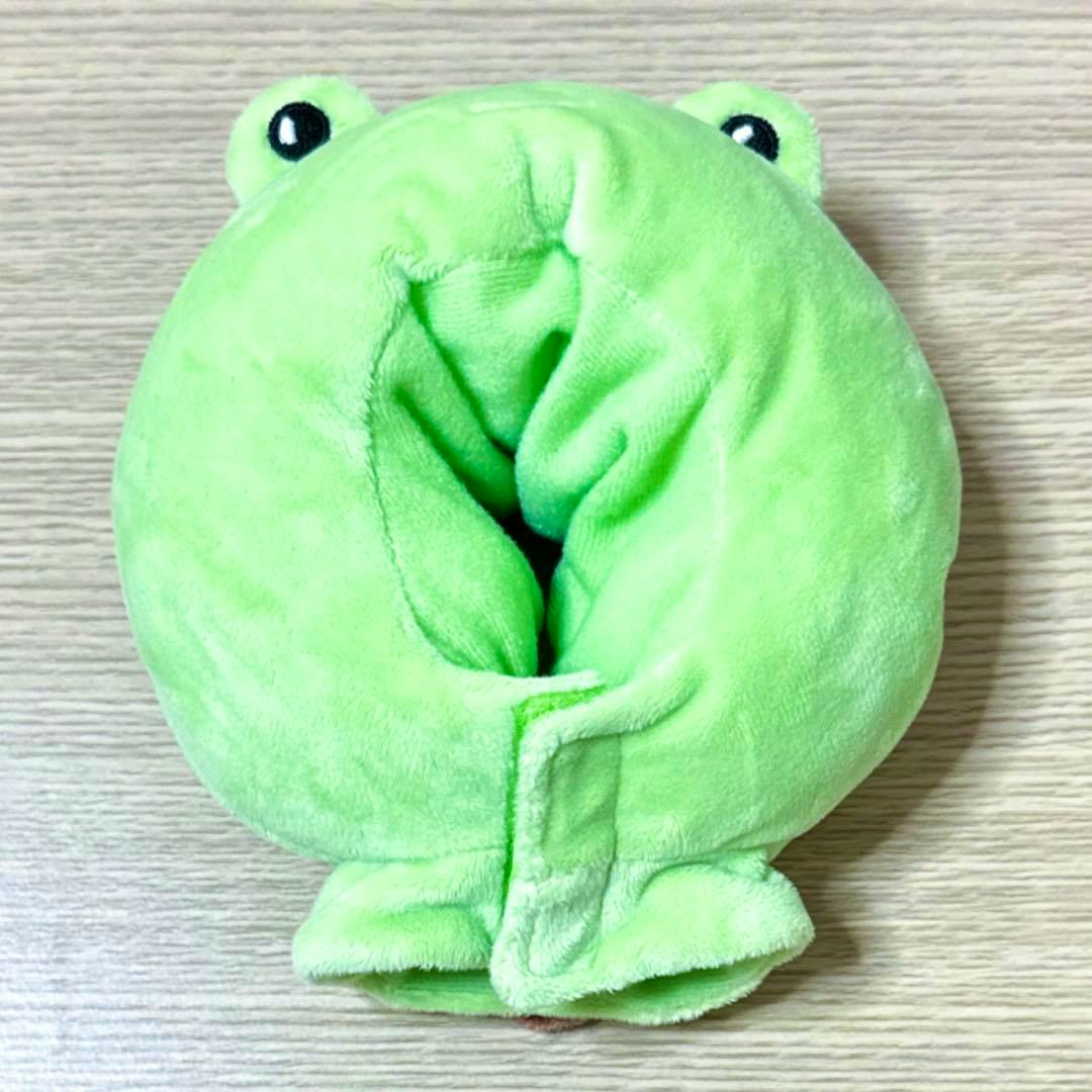 A green plush light stick cape cover laid flat on a wooden surface.