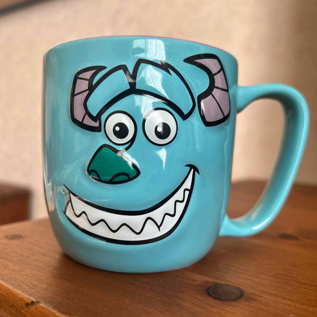 Light blue ceramic mug showing Sulley (Monsters, Inc.) face printed on the front.