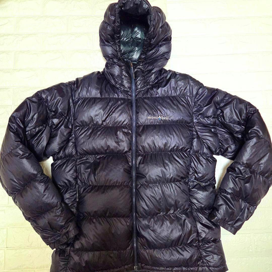 Black mont-bell alpine down jacket with hood laid flat showing the front zipper and mont-bell logo.