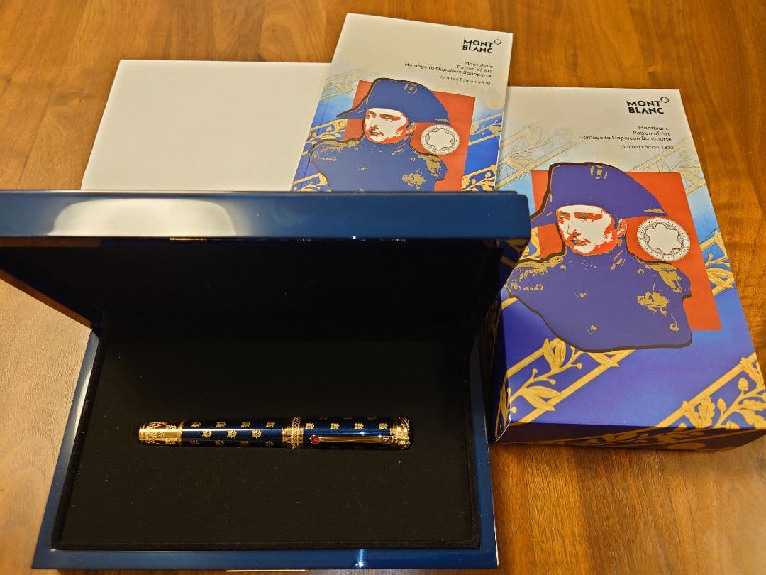 A Montblanc Napoleon fountain pen displayed inside an open presentation box with decorative outer boxes beside it.