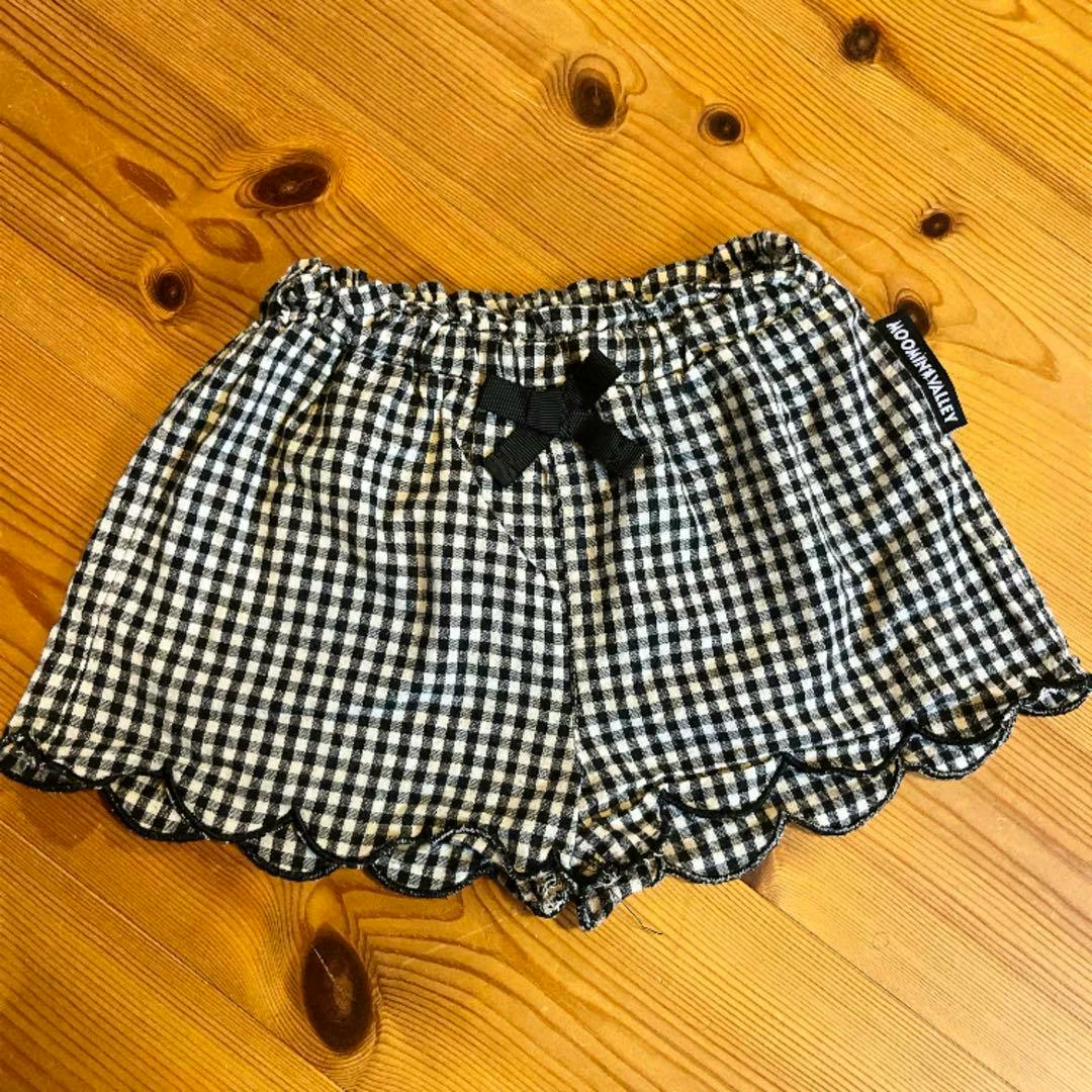 Black-and-white gingham check Moomin Little My children’s shorts (90cm) laid flat showing the front with a small bow and scalloped hem.